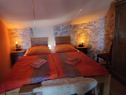 Schlafzimmer mit individuellen Nachttischlampen und antikem Schrank